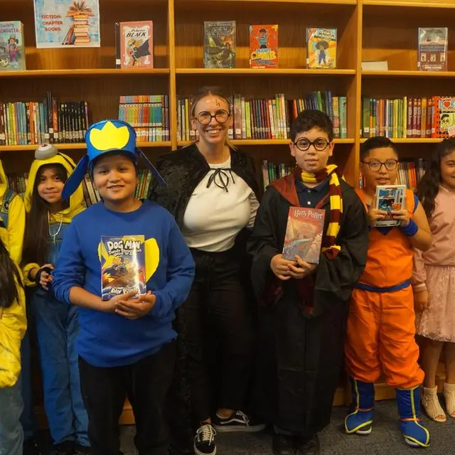 Scholars and a teacher in the library, dressed as book characters and holding books