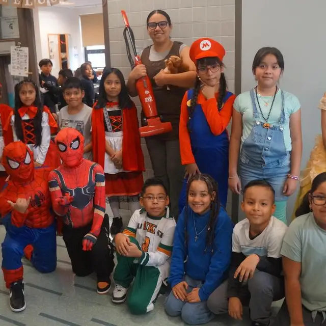 A class in costume, including two Spider-Man suits and a plumber in a red cap