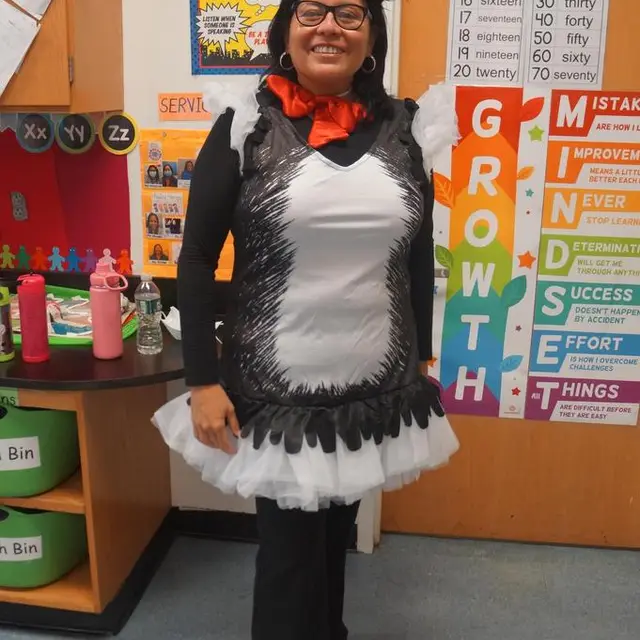 A teacher dressed as a penguin in a classroom