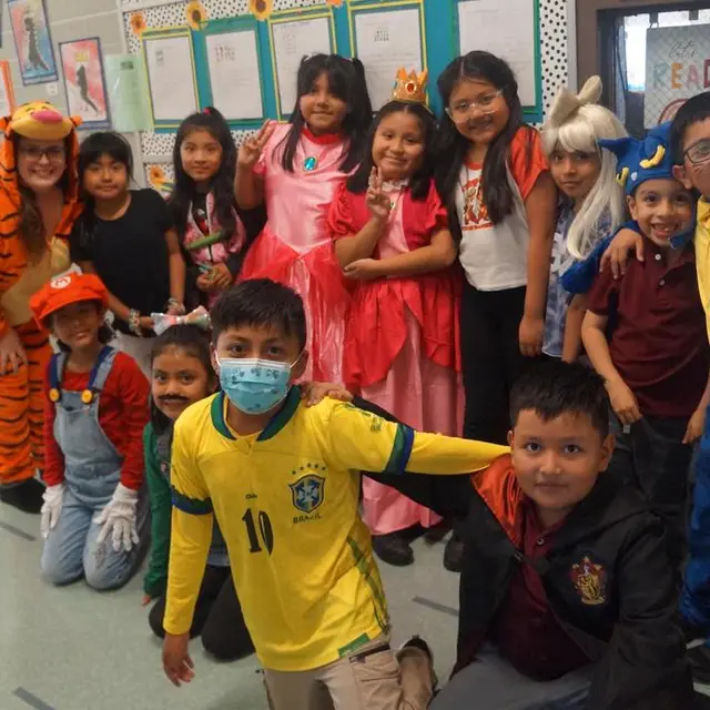 A class in costume, one scholar in a yellow soccer jersey