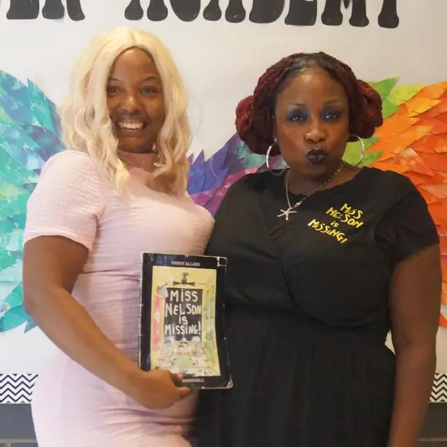 Two staff members in costume holding the book “Miss Nelson Is Missing!”