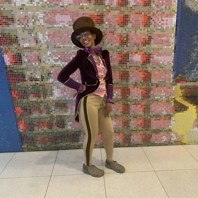 A staff member dressed as a chocolate maker in a top hat in front of the lobby mosaic