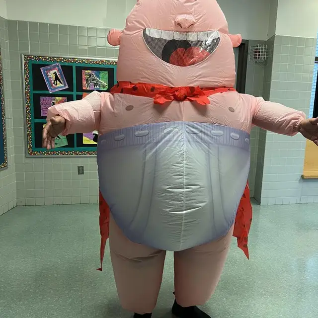 A scholar in an inflatable superhero costume with a red cape